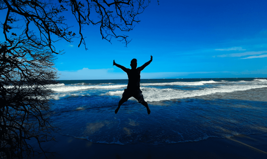 A Man Jumping in Front of the Ocean